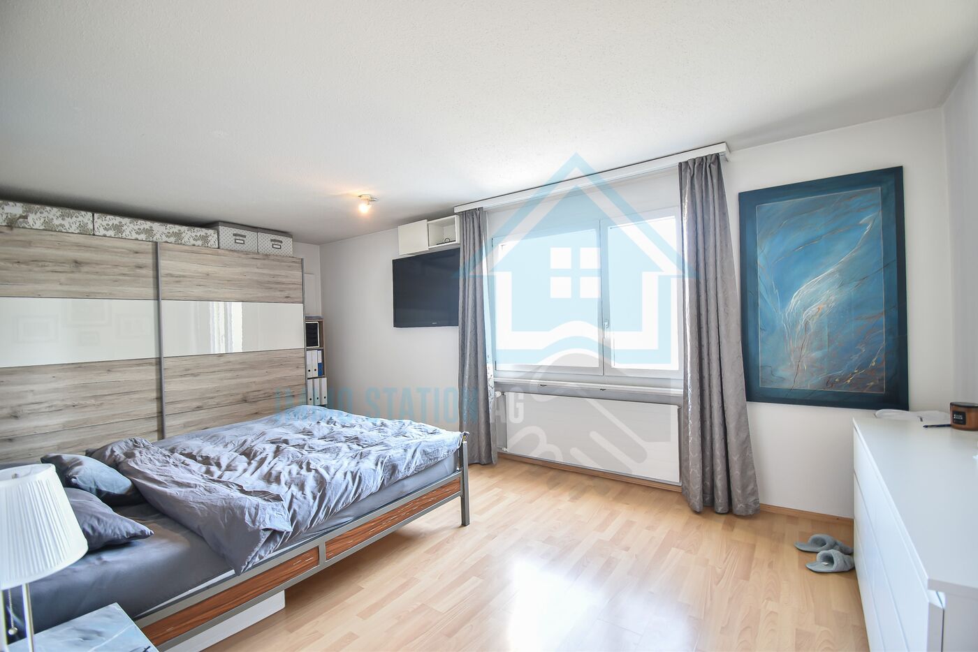 Helles Schlafzimmer mit Bett und Fensterfront