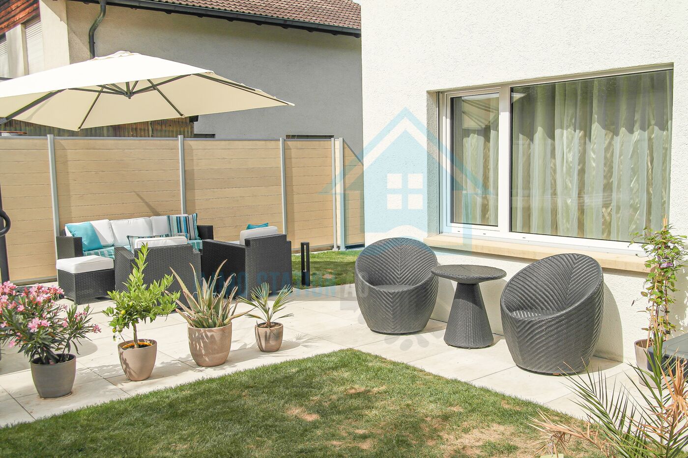 Terrasse mit Lounge-Möbeln und Garten
