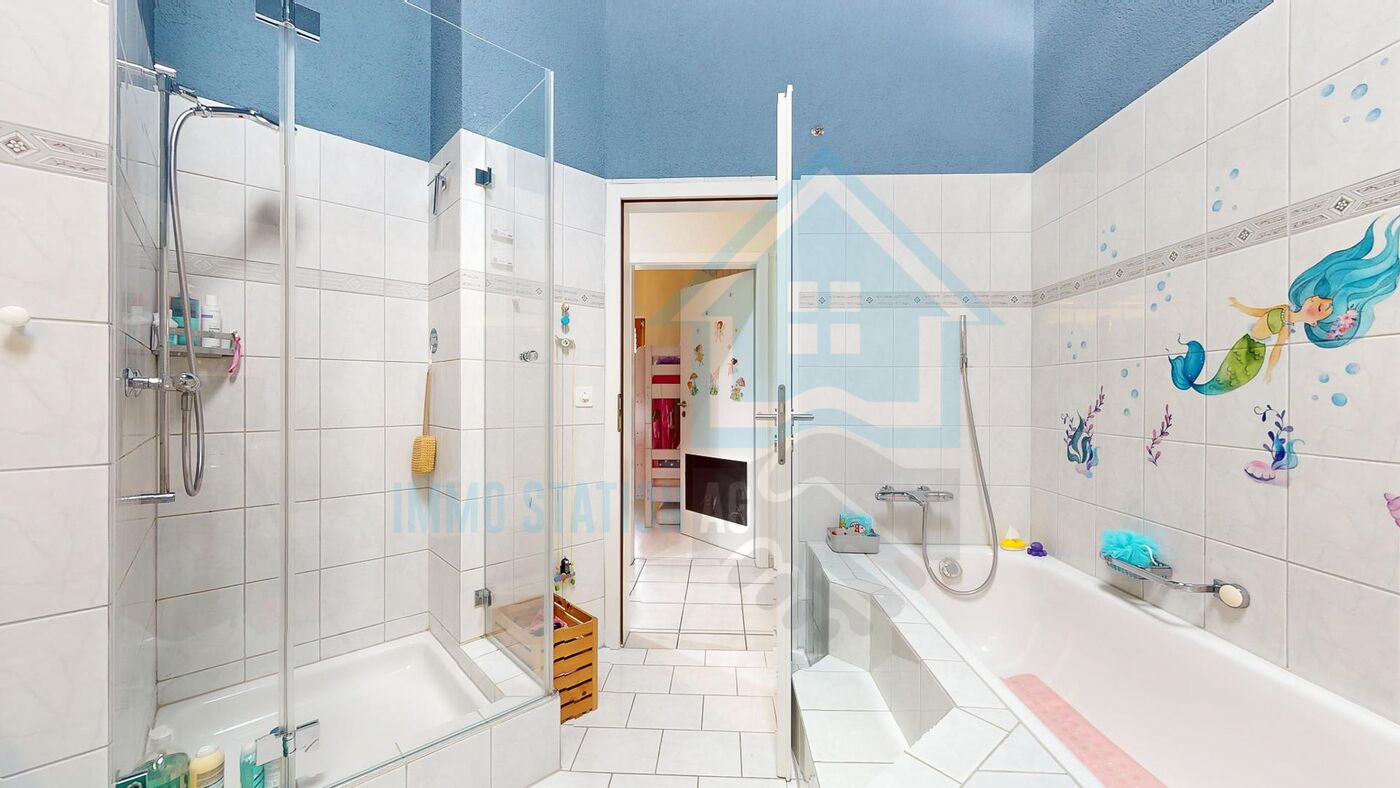 Badezimmer mit Badewanne und Duschbereich