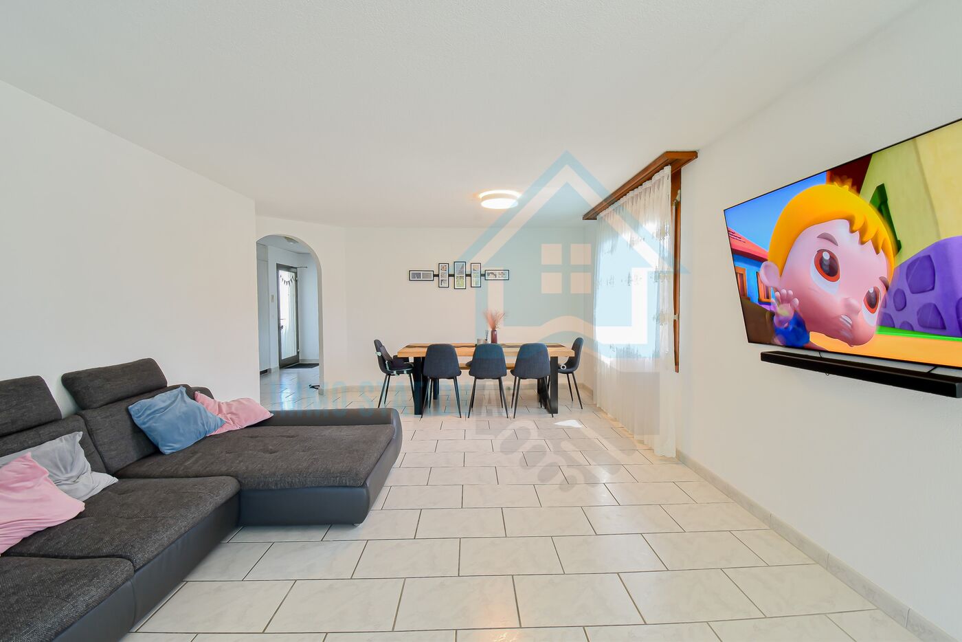 Offener Wohn- und Essbereich mit Sofa und Fernseher