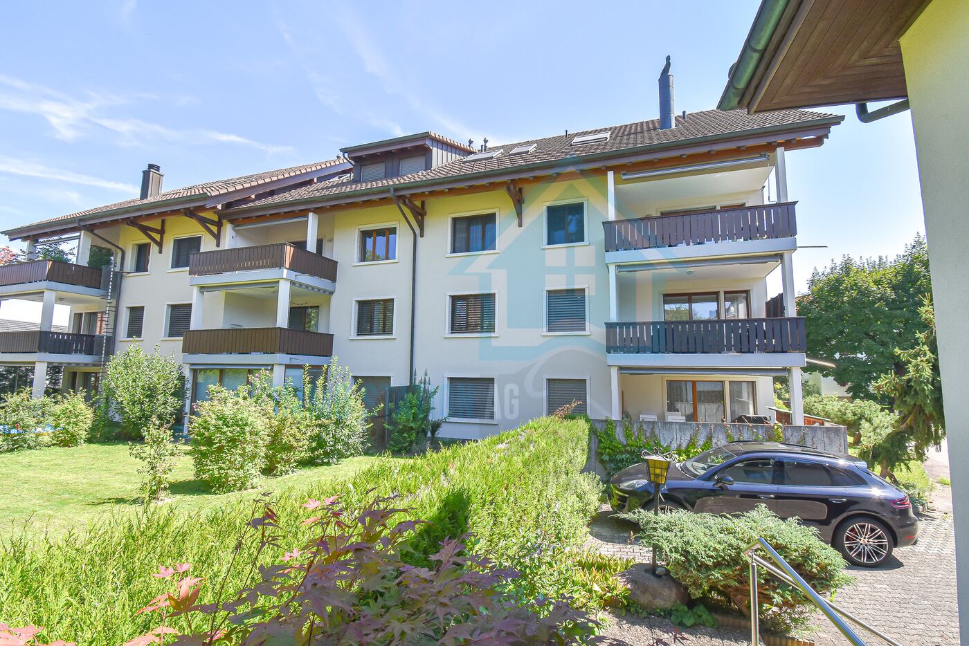 Mehrfamilienhaus mit Balkonen und Gartenansicht