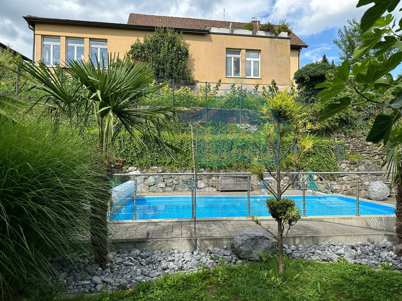 Außenansicht eines Hauses mit Pool und Garten