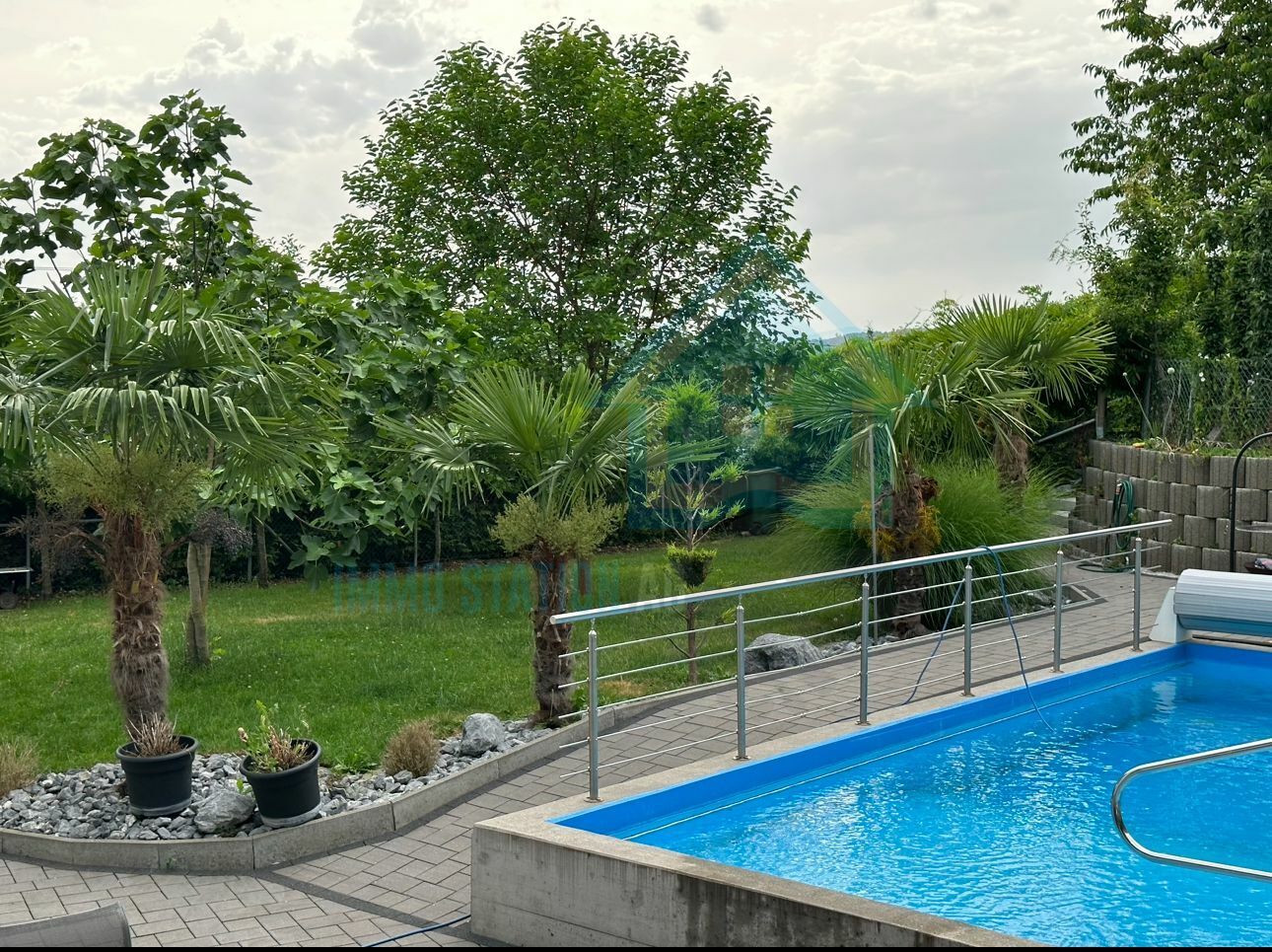 Außenbereich mit Pool und tropischer Gartengestaltung