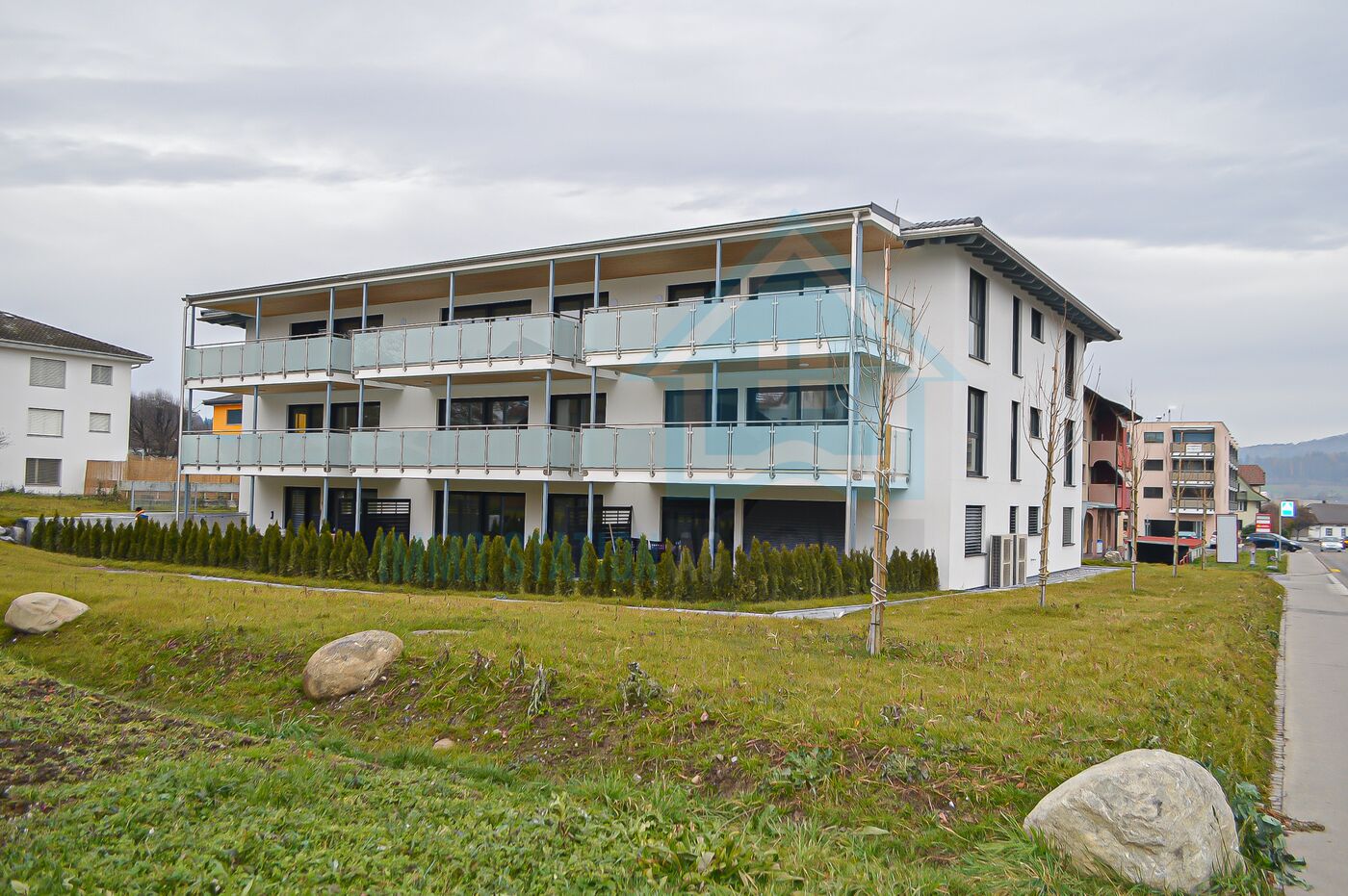 Mehrfamilienhaus mit Balkonen und Grünstreifen