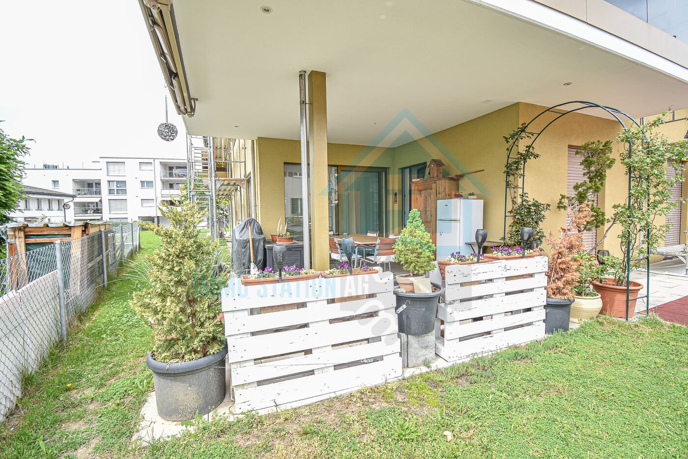 Überdachte Terrasse mit Garten und Nachbarbebauung