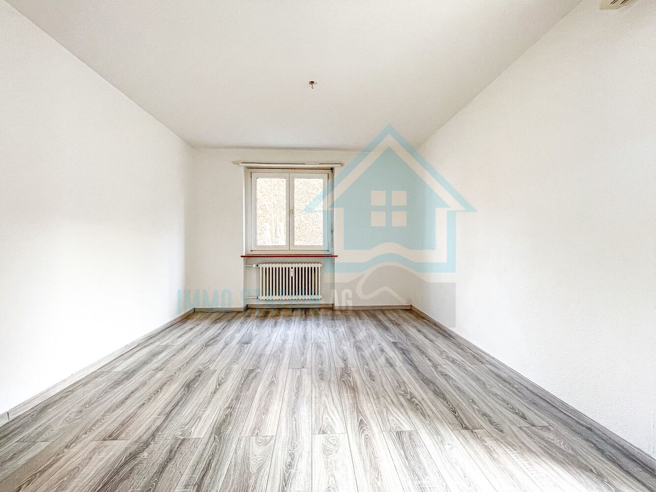 Leerer, renovierter Raum mit Dachschräge und Laminatboden