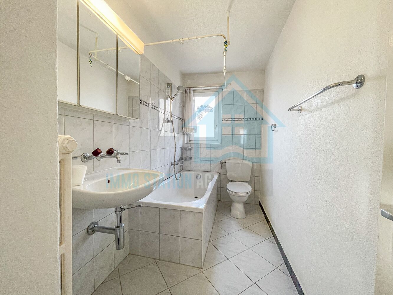 Kleines Badezimmer mit Badewanne, Waschbecken und WC