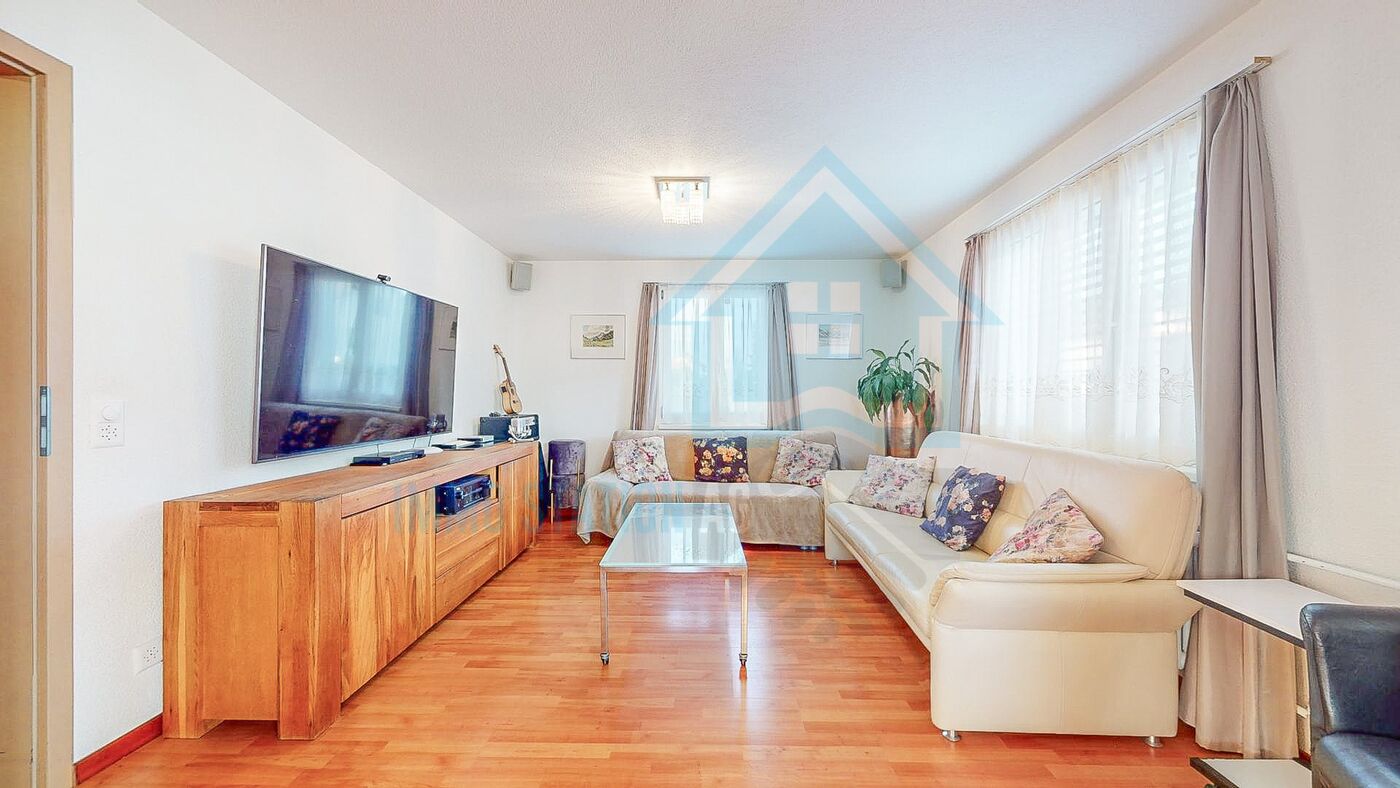 Helles Wohnzimmer mit Ecksofa und TV
