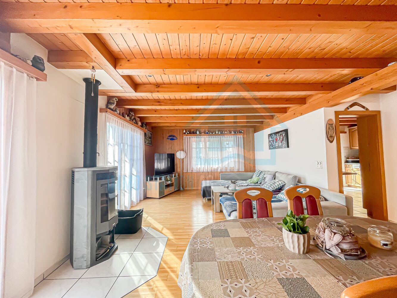 Gemütliches Wohnzimmer mit Holzdecke und Kaminofen
