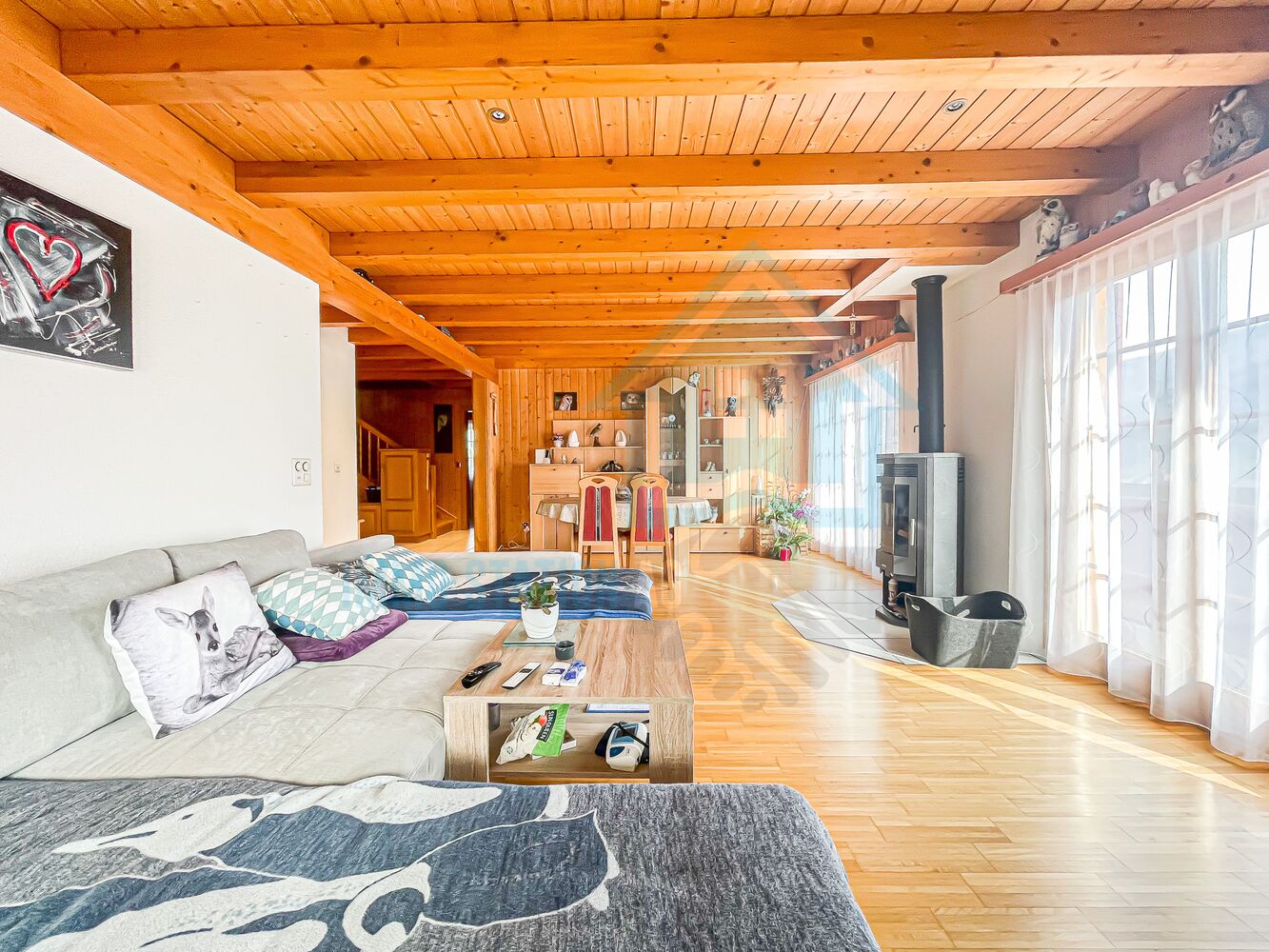 Gemütliches Wohnzimmer mit Holzdecke und Kaminofen