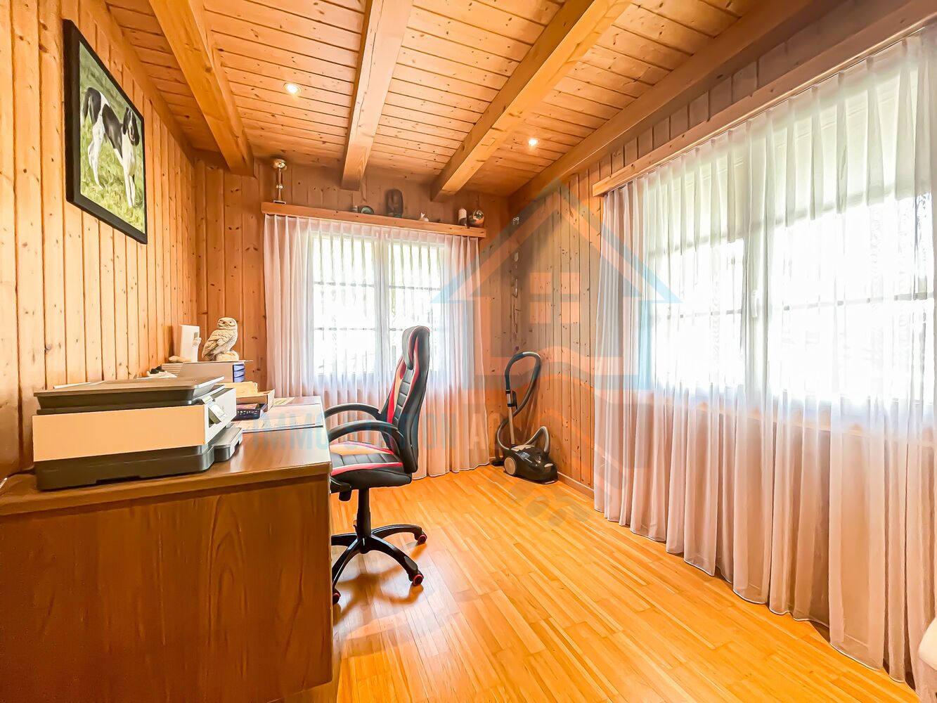 Holzverkleidetes Arbeitszimmer mit großen Fenstern