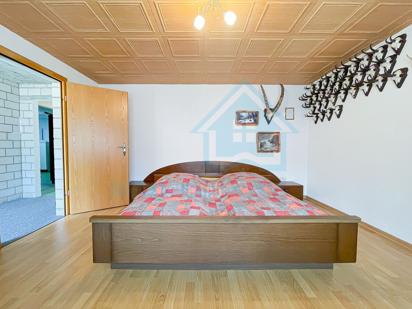 Schlafzimmer mit Holzbett und dekorativer Decke