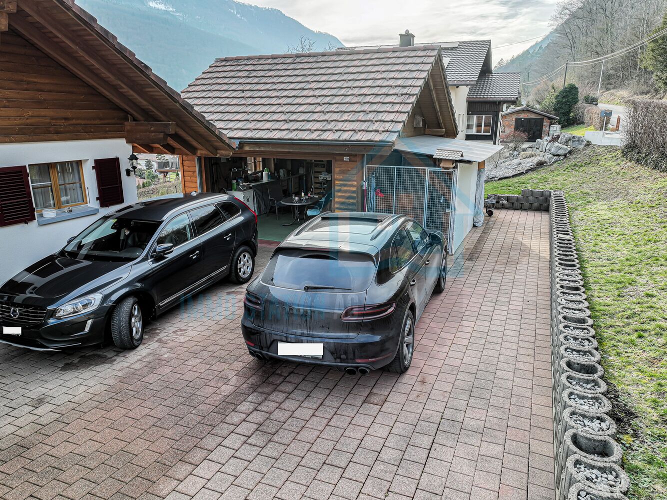 Außenansicht mit Einfahrt und zwei Autos