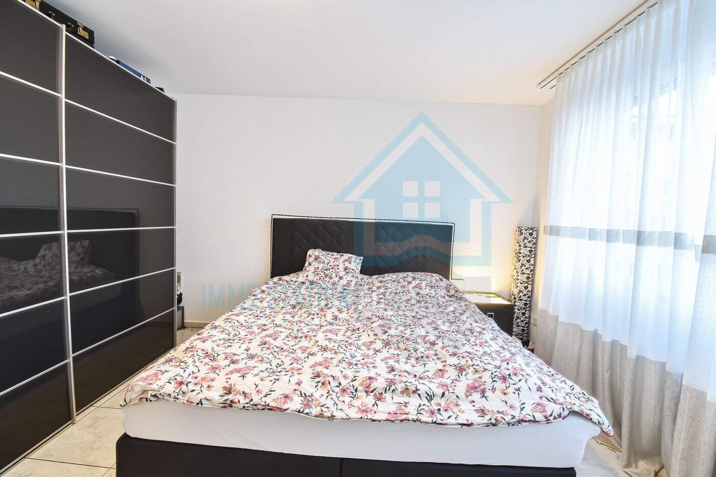 Modernes Schlafzimmer mit großem Bett und Schrankwand