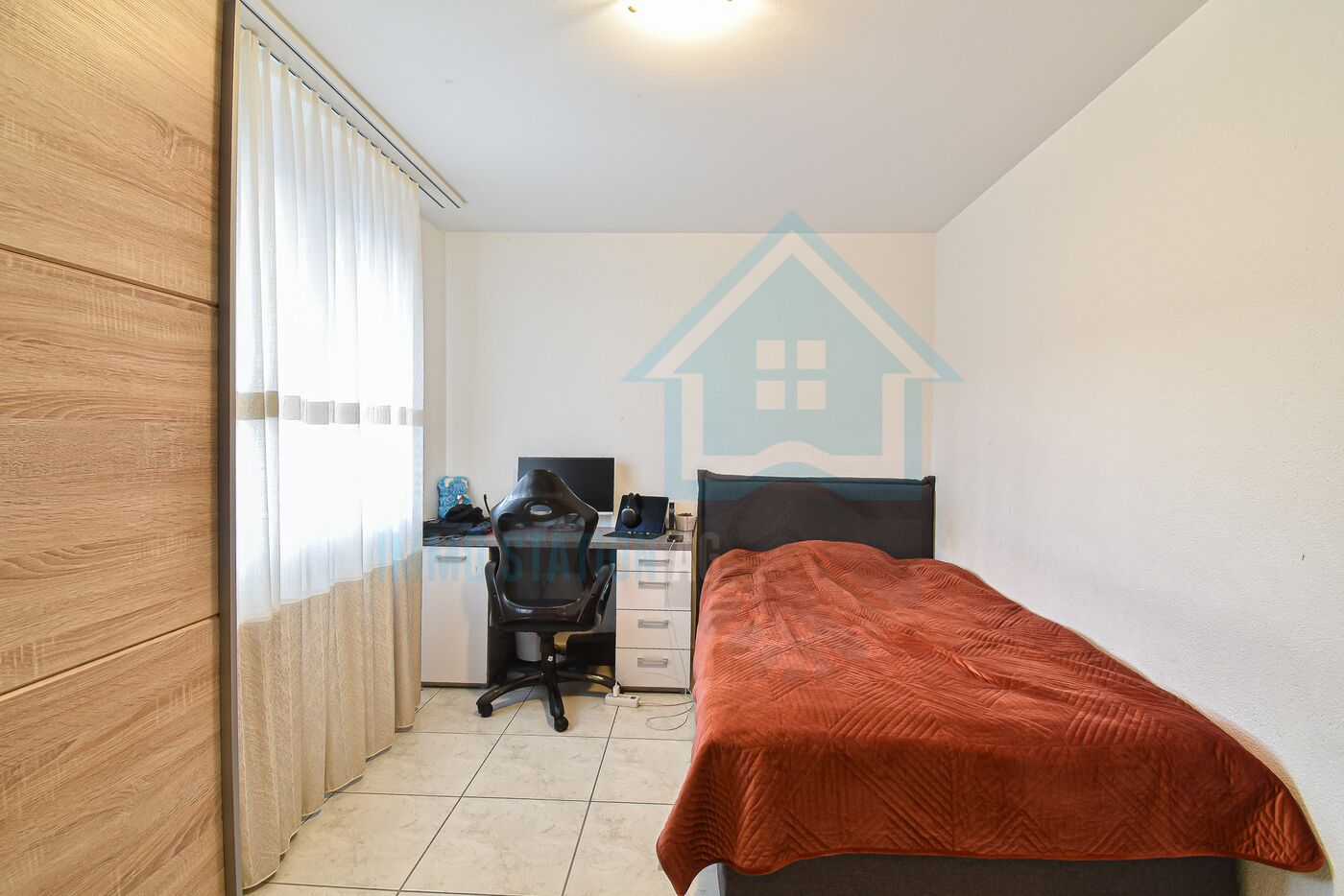 Kleines Schlafzimmer mit Schreibtisch und Einzelbett