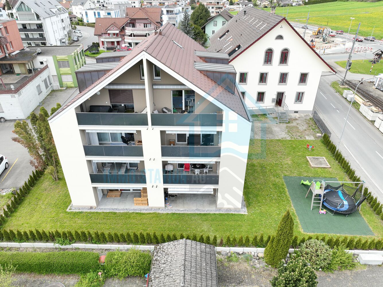 Luftaufnahme eines Mehrfamilienhauses mit Garten