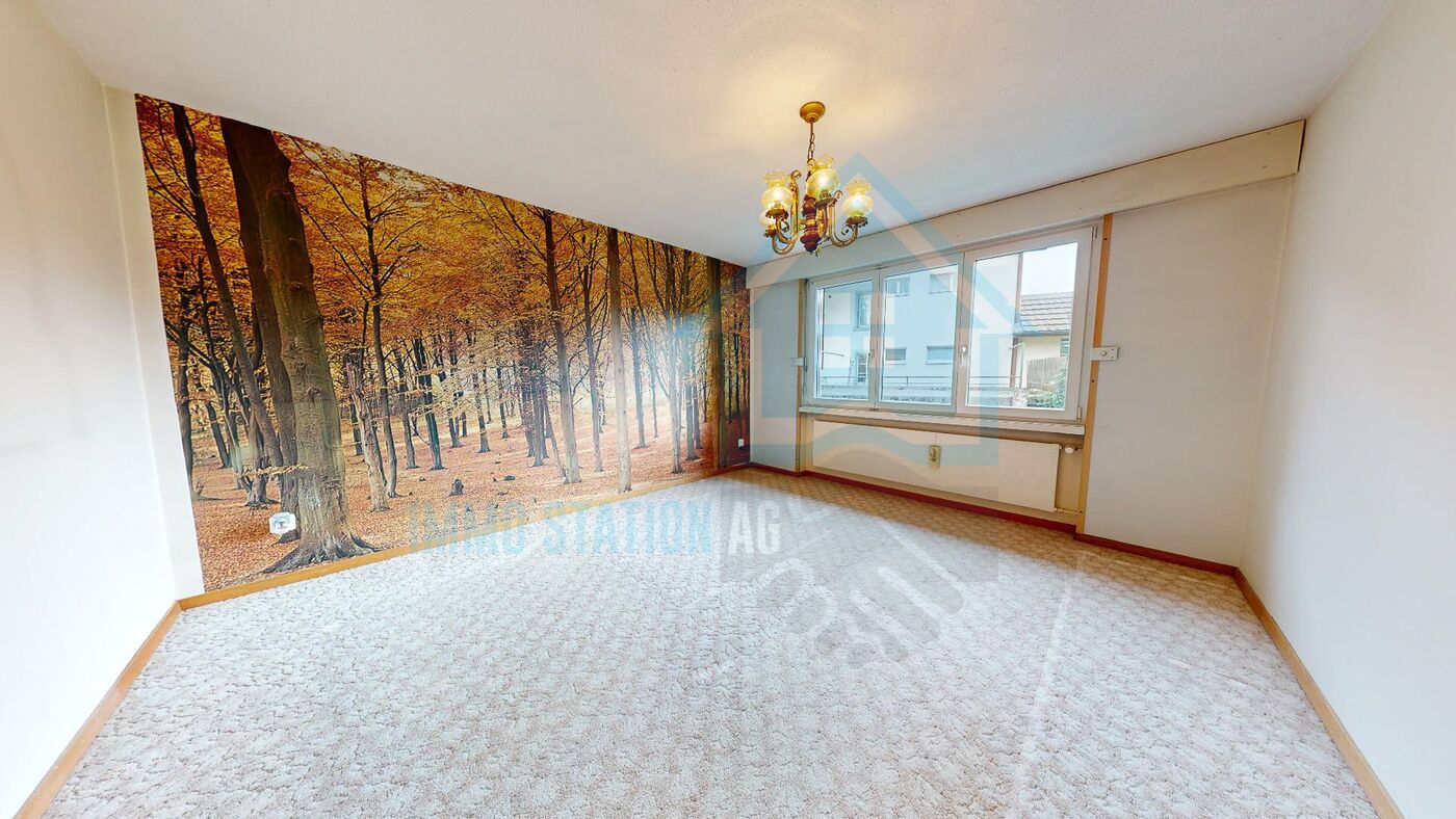 Helles Zimmer mit Waldtapete und großem Fenster