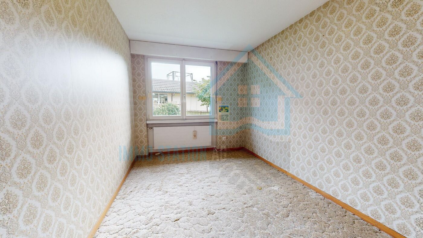 Kleines Zimmer mit Tapetenmuster und Fenster