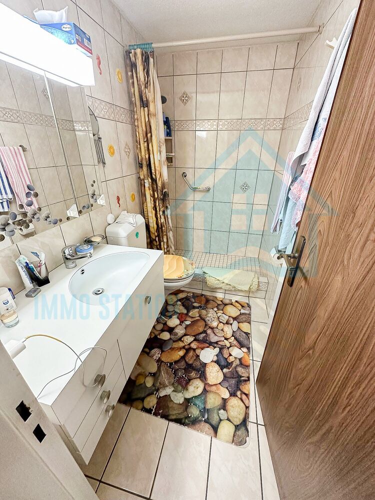 Kleines Badezimmer mit Dusche und Waschtisch