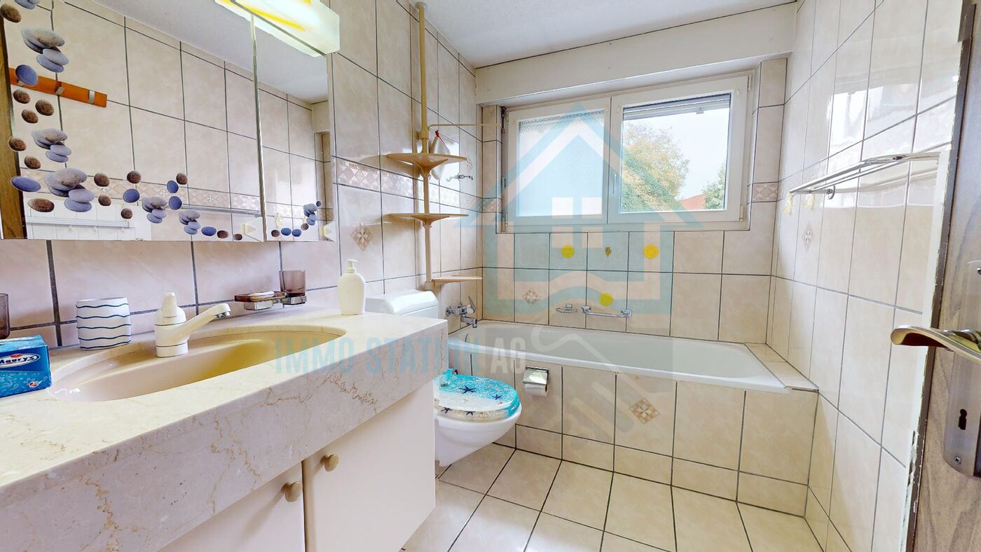 Kleines Badezimmer mit Badewanne und Waschtisch