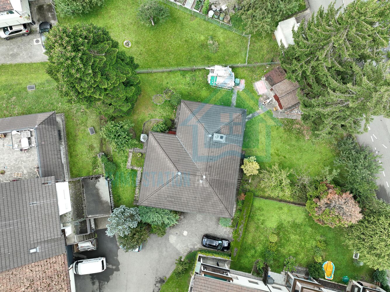 Drohnenaufnahme eines Wohngrundstücks mit Garten und Hausdächern