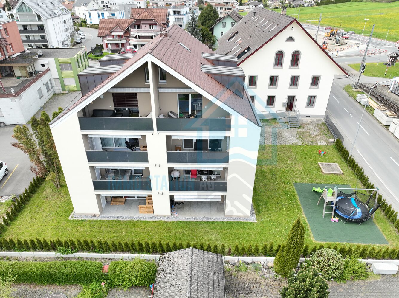 Luftaufnahme eines Mehrfamilienhauses mit Garten