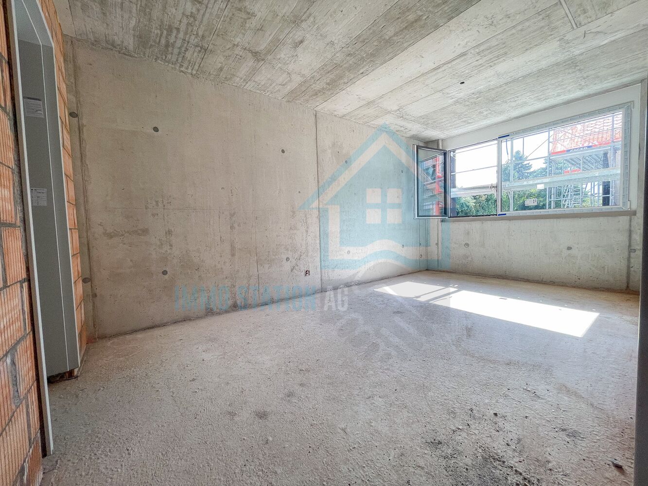 Unausgebauter Rohbau mit Fenster und Betonflächen