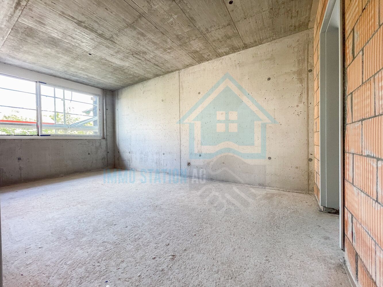 Rohbau-Raum mit Beton und Ziegelwand