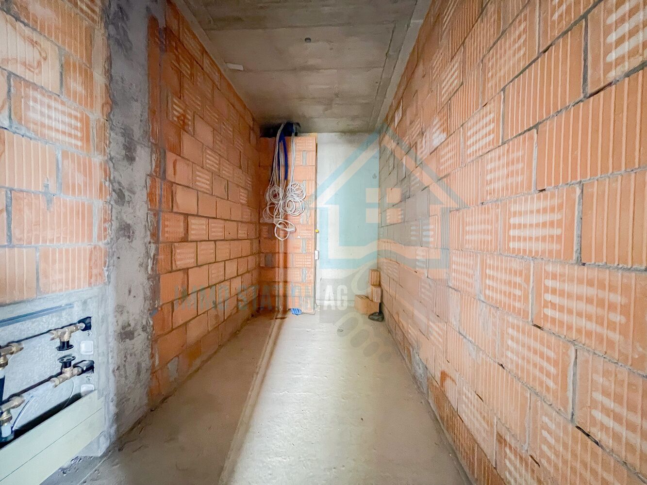 Unvollständiger Rohbau-Flur mit sichtbarer Installation