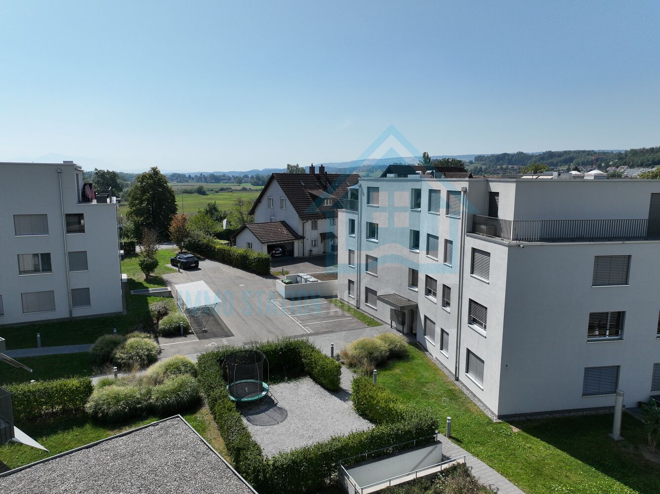 Außenansicht einer Wohnanlage mit Garten und Landschaftsblick