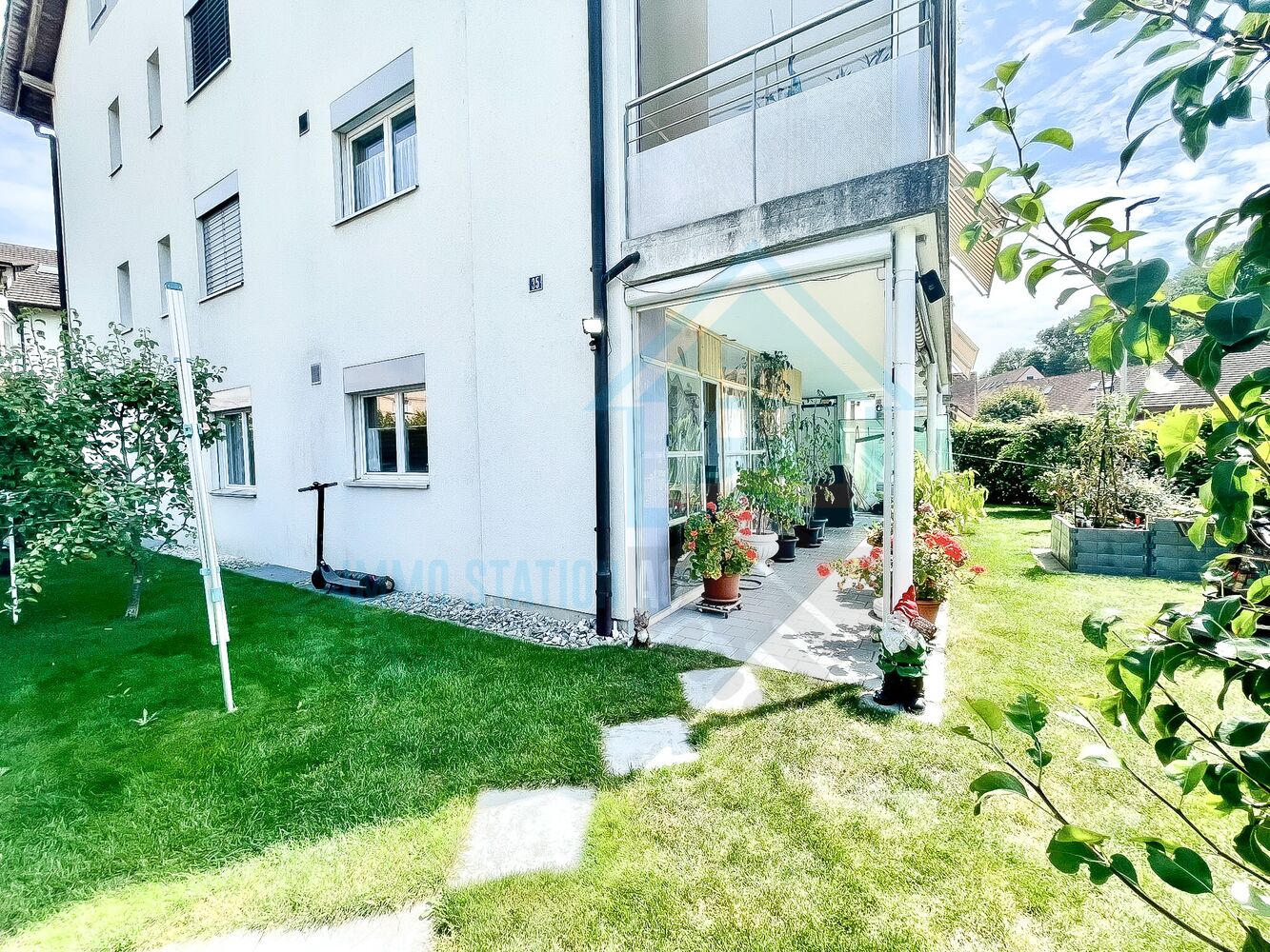 Gartenansicht eines Wohnhauses mit Wintergarten