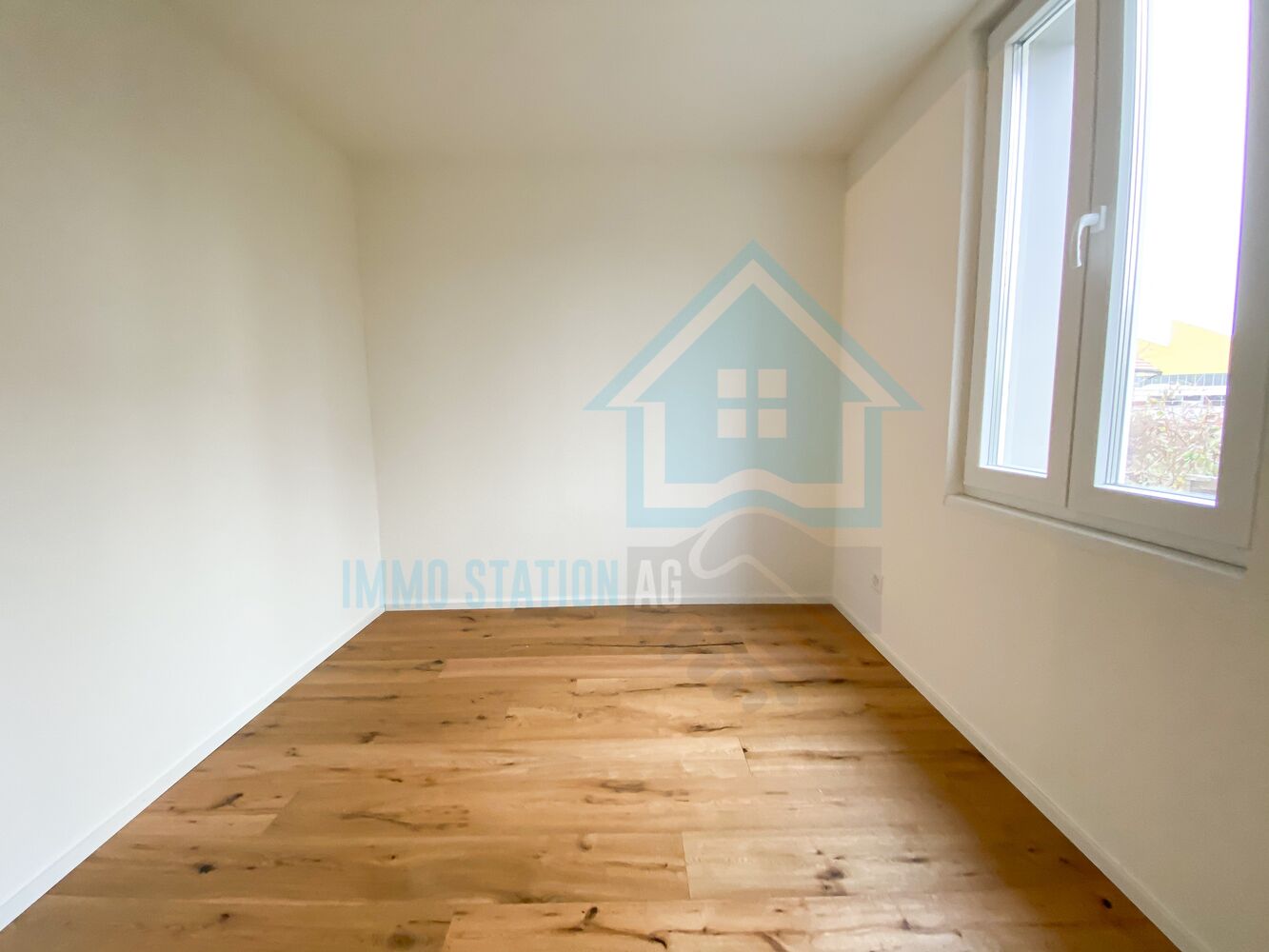 Leeres, helles Zimmer mit Holzfußboden