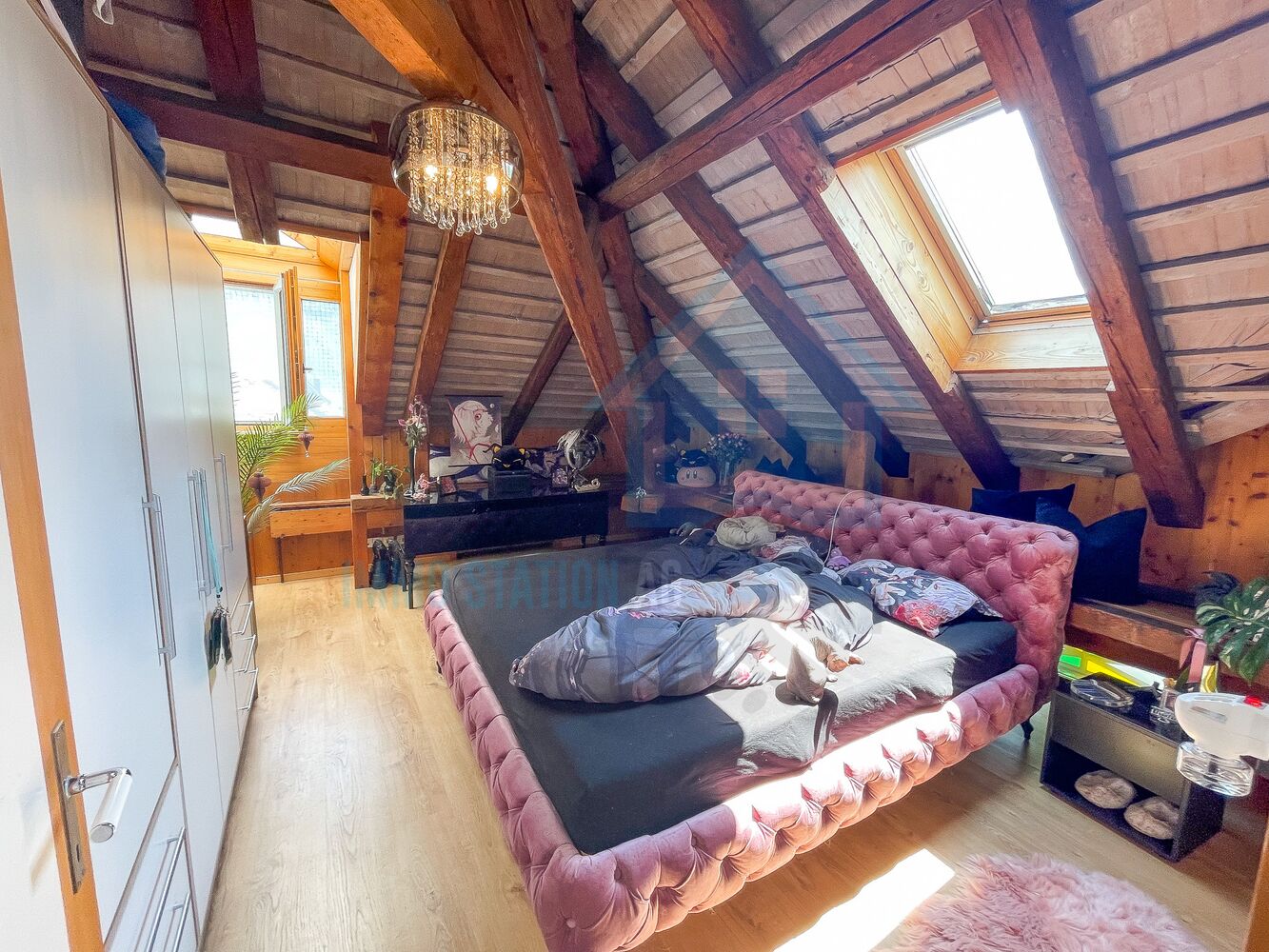 Dachgeschoss-Schlafzimmer mit sichtbaren Holzbalken