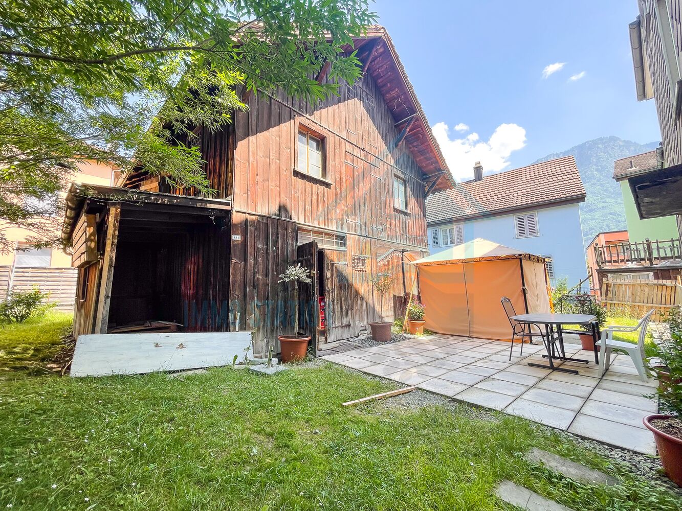Rustikaler Innenhof mit Holzhaus und Sitzbereich