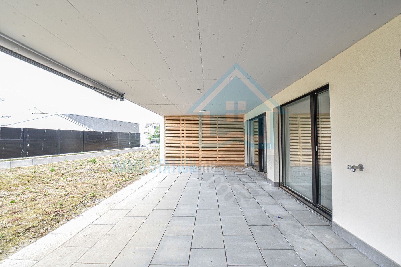Überdachte Terrasse mit großformatigen Fliesen