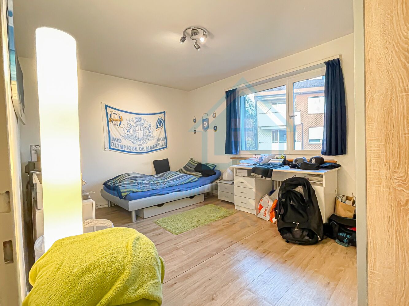 Helles Schlafzimmer mit Fenster und Schreibtisch