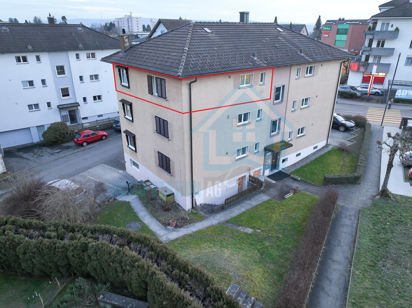 Mehrfamilienhaus mit Walmdach und umliegendem Grundstück