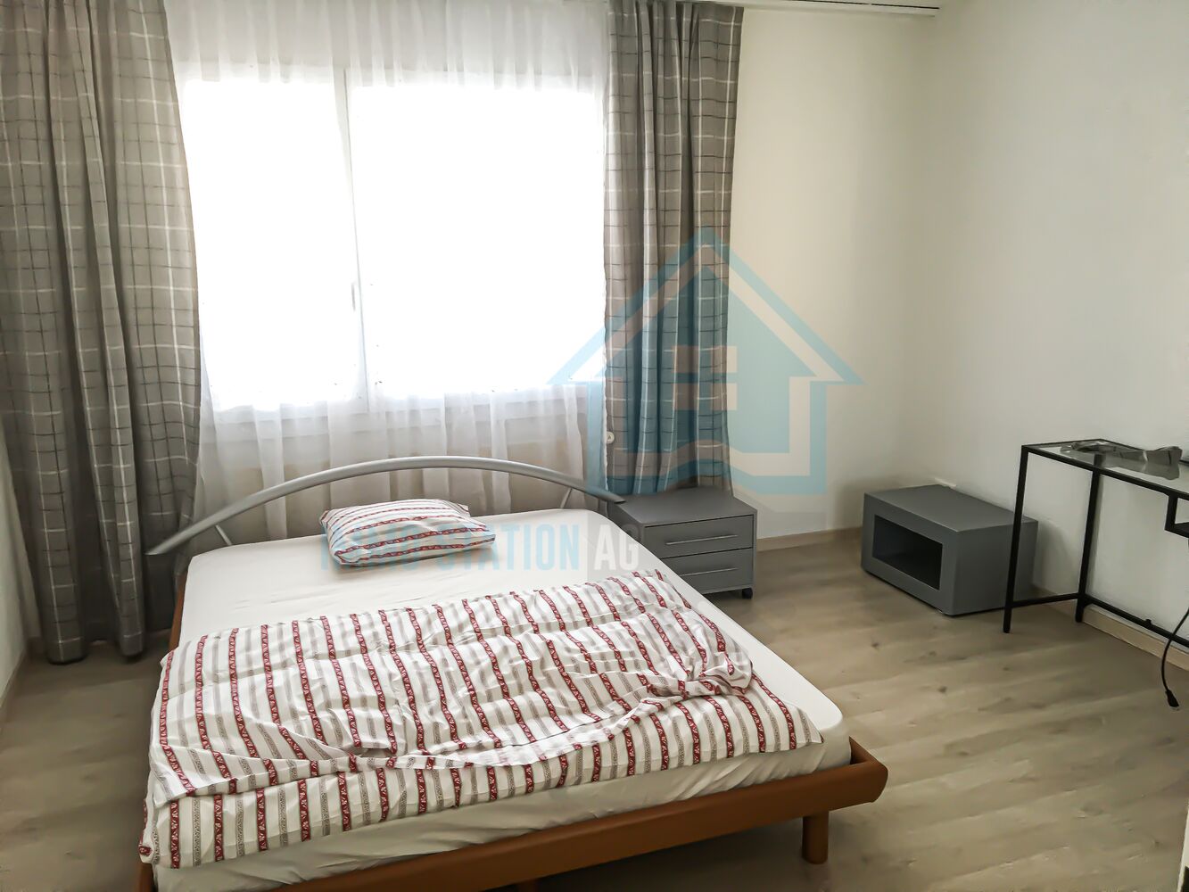 Helles Schlafzimmer mit Bett und Gardinen
