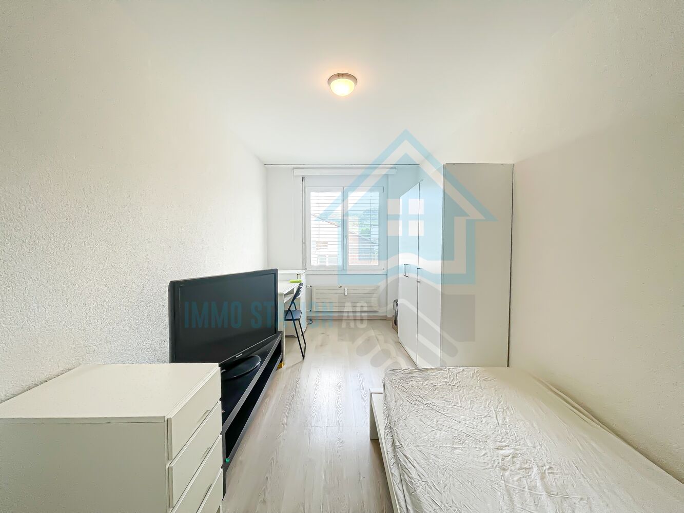 Schmales Schlafzimmer mit Einzelbett und Schreibtisch