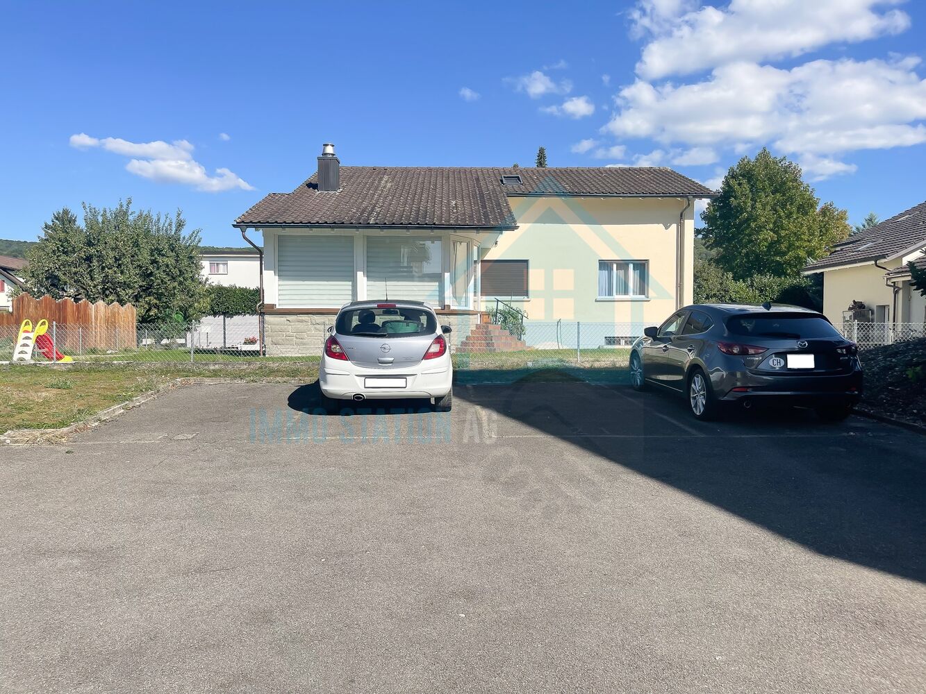 Einfamilienhaus mit Zufahrt und geparkten Autos