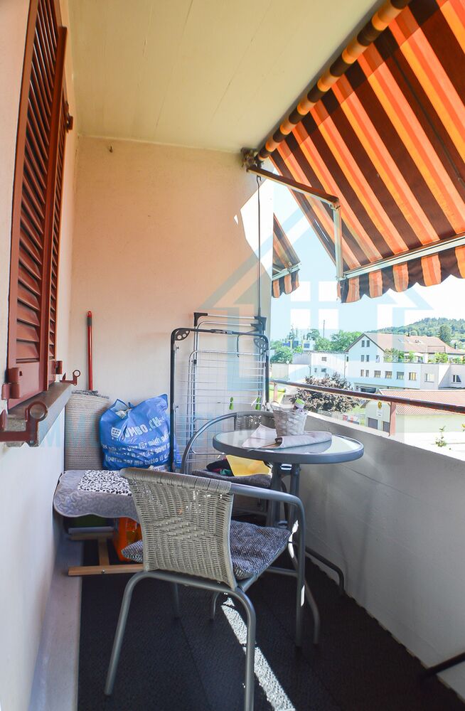 Überdachter Balkon mit Sitzgruppe