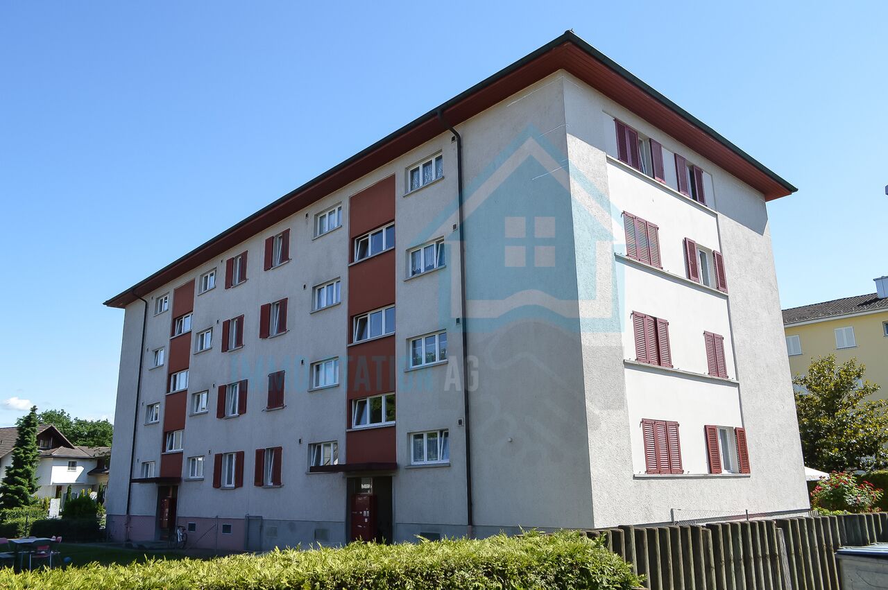 Mehrfamilienhaus mit Satteldach und Fensterläden