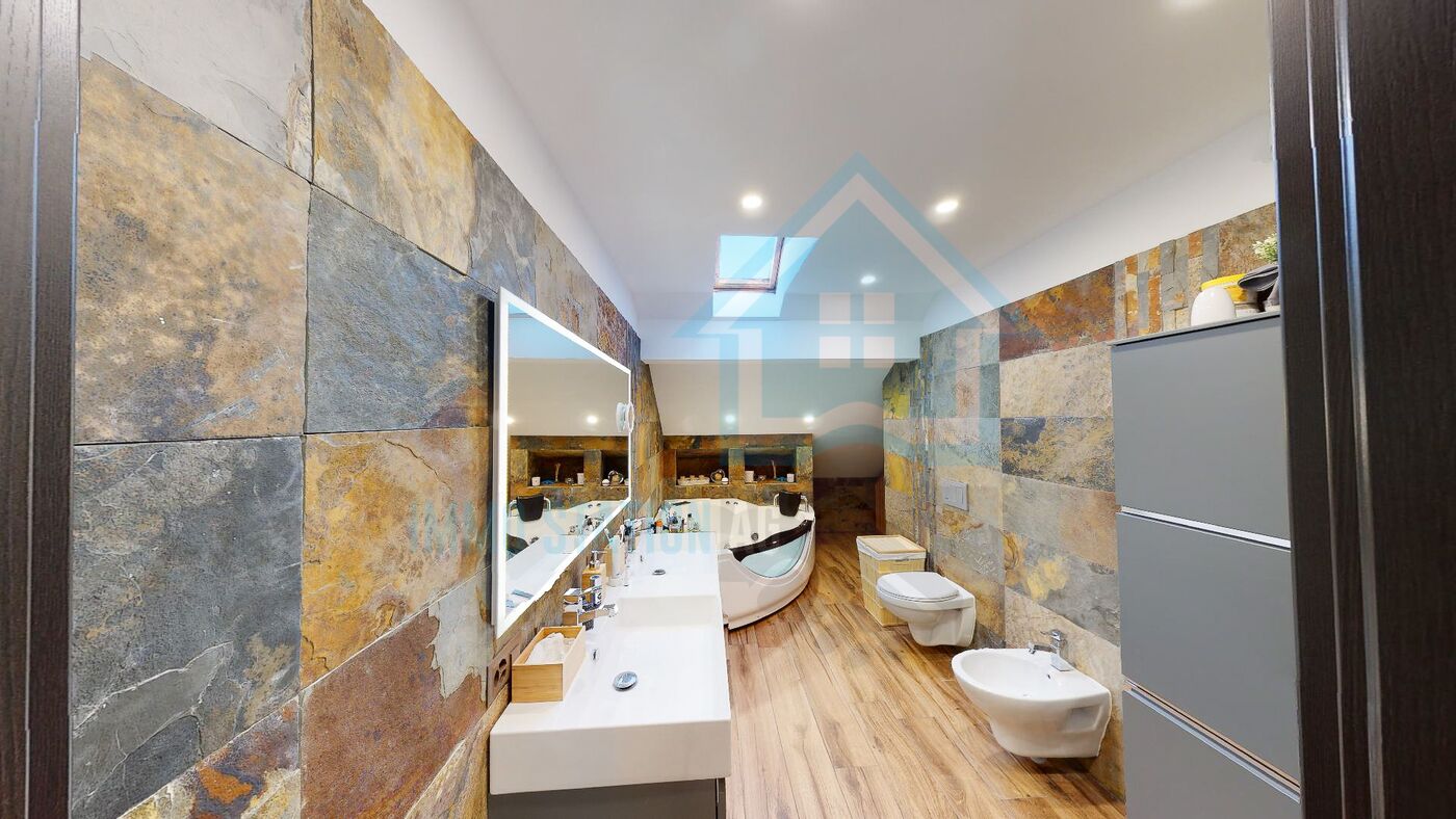 Modernes Badezimmer mit Dachfenster und Natursteinwänden