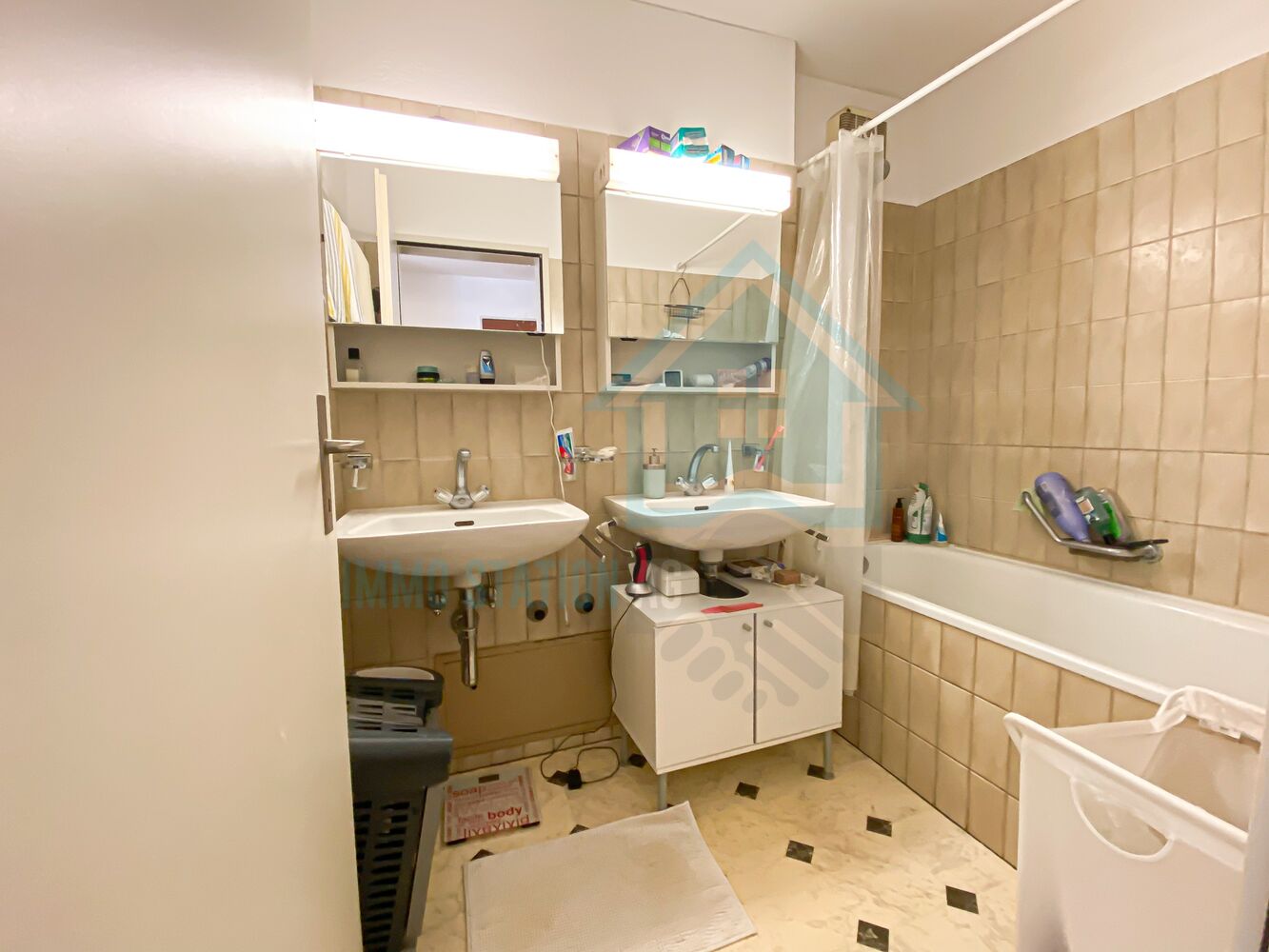 Badezimmer mit Doppelwaschtisch und Badewanne