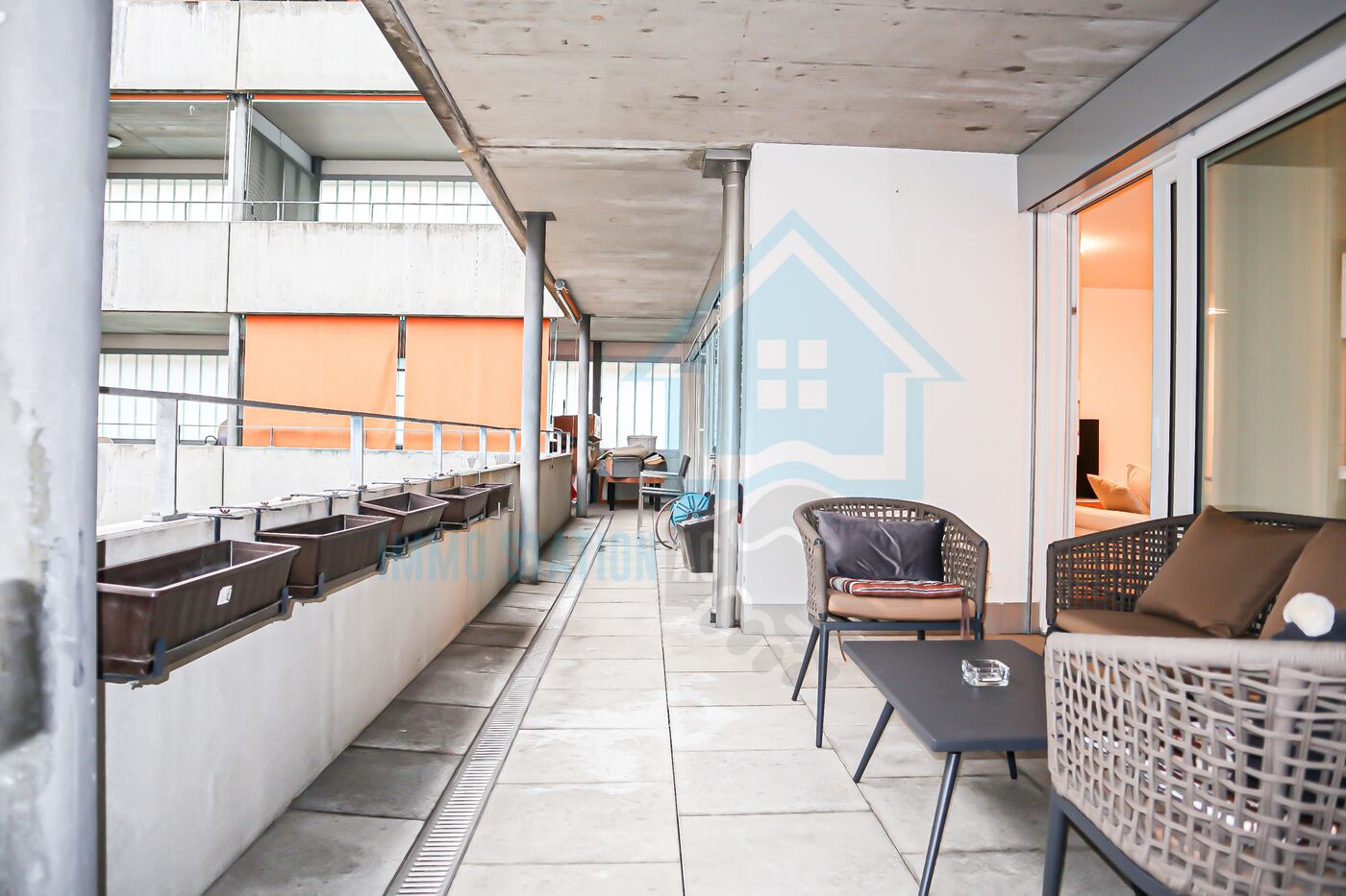 Überdachter Balkon mit Sitzgruppe
