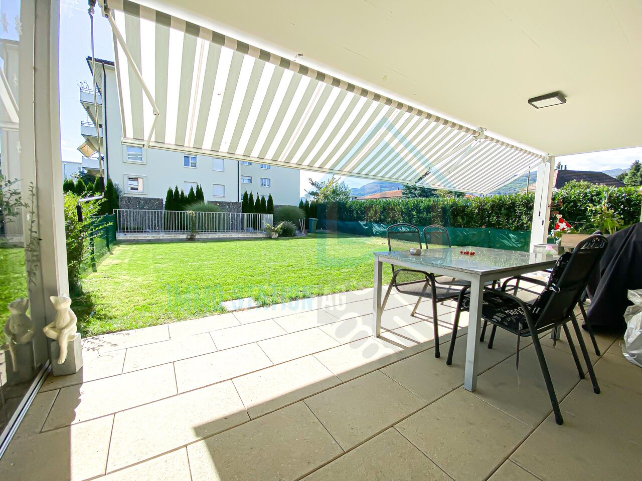 Überdachte Terrasse mit Gartenblick