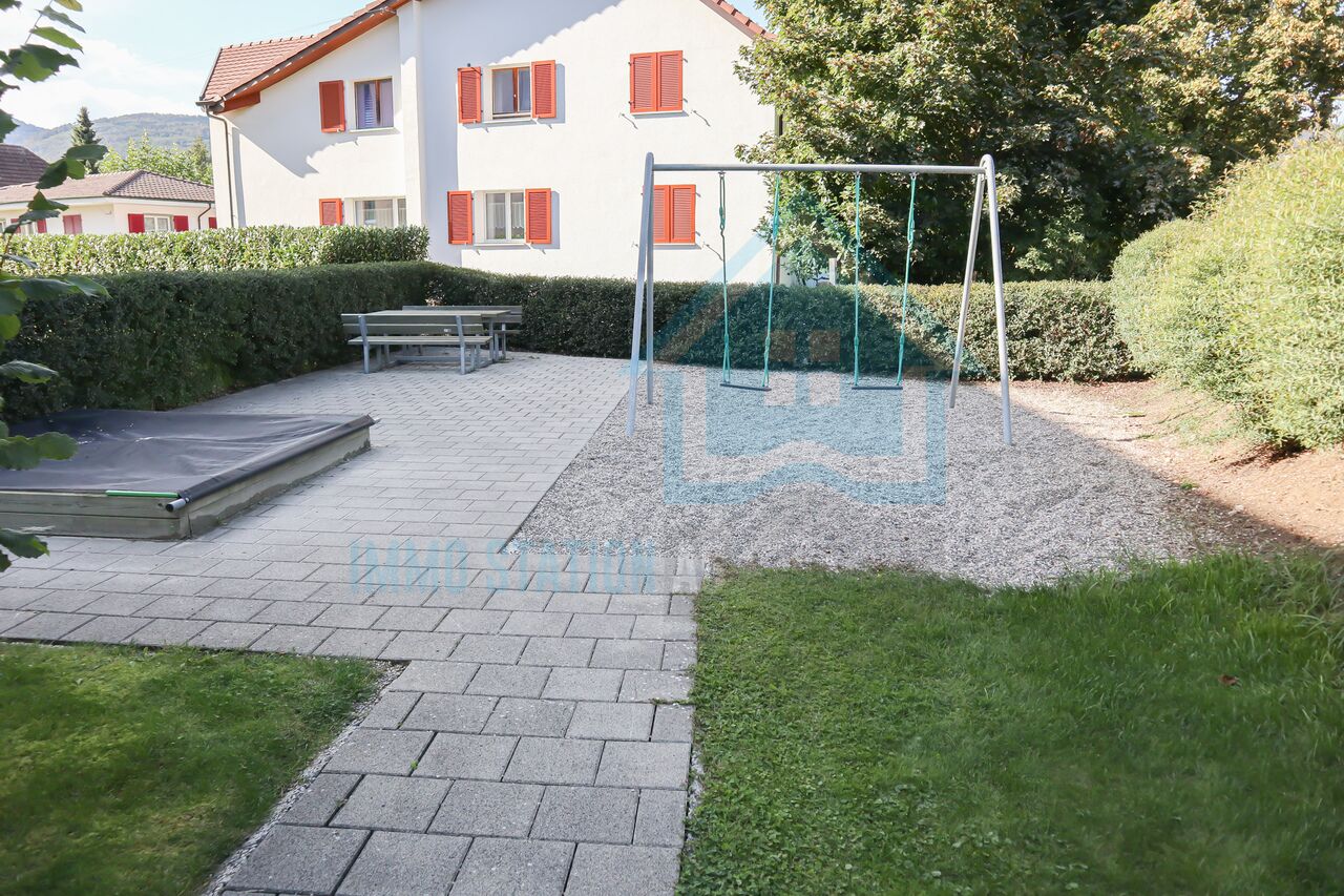 Garten mit Spielbereich vor einem Wohnhaus