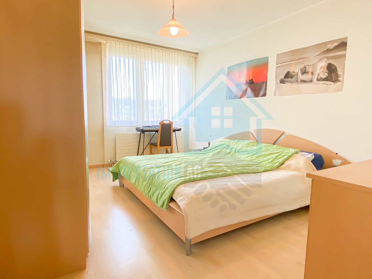 Helles Schlafzimmer mit Doppelbett und Fenster