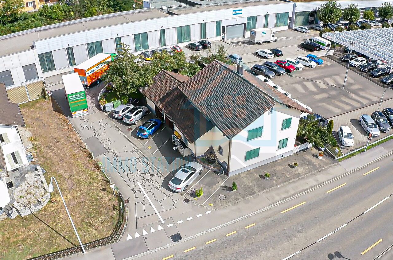 Gewerbegebäude mit Parkplatz und Zufahrt