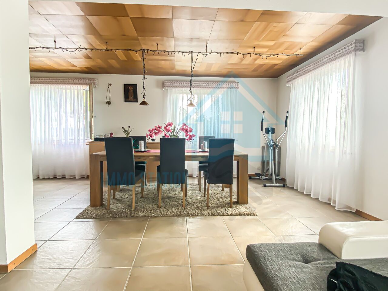 Esszimmer mit großen Fenstern und Holzbalkendecke